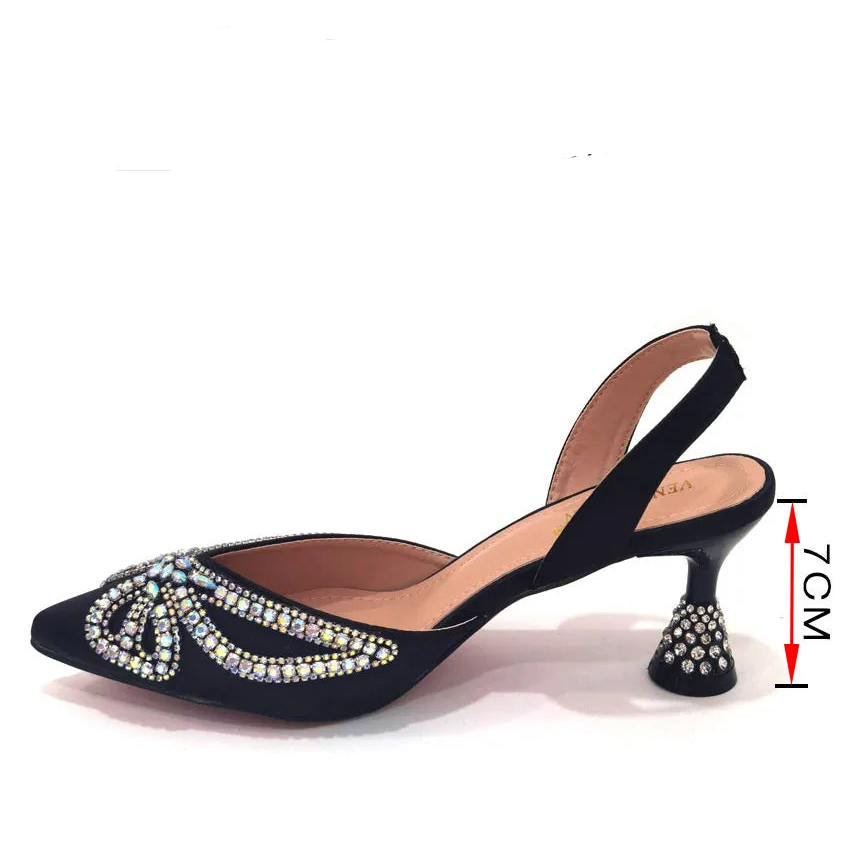 Black high-heeled shoe with rhinestone details on a white background, featuring brand information and size options.