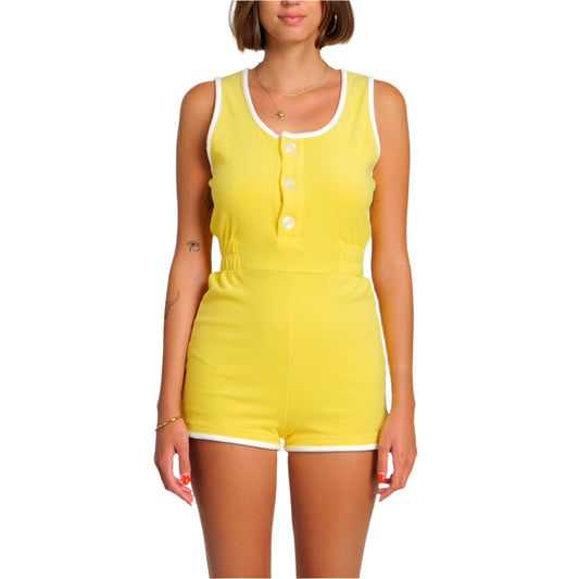 Woman wearing a yellow sleeveless jumpsuit on a white background